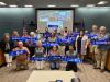 The Civics Academy's Class of 2022 with Councilors in the Council Chambers, holding up their graduation gift.